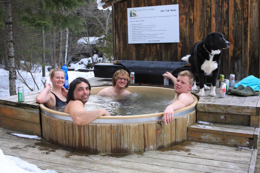 Photo of Three Friends in a Hot Tub While Winter Camping in Ontario