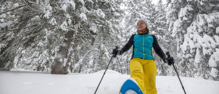 Photo of a Woman Snowshoeing near the Eco-Lodge. Check Out Our Winter Bucket List!